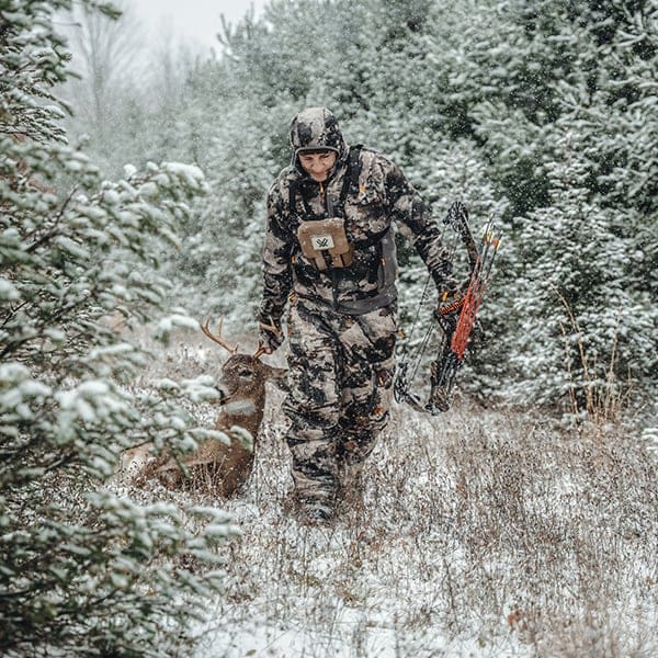 Man dragging his buck wearing Scentlok BE:1 during late season